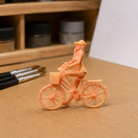 Peach Plastic Girl Bike Figurine Spoked Wheels Girl on Cycle Figure